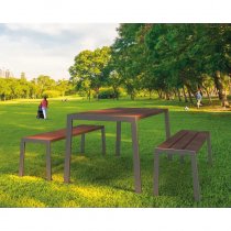 Silaos picknickbord i återvunnen plast med två bänkar i parkmiljö, med mörkbrun träliknande plast och färgad stålstomme.