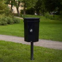 Papperskorg med lock i parkmiljö