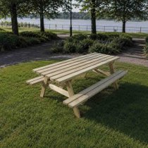 Bänkbord i trä placerad i parkområde vid sjö